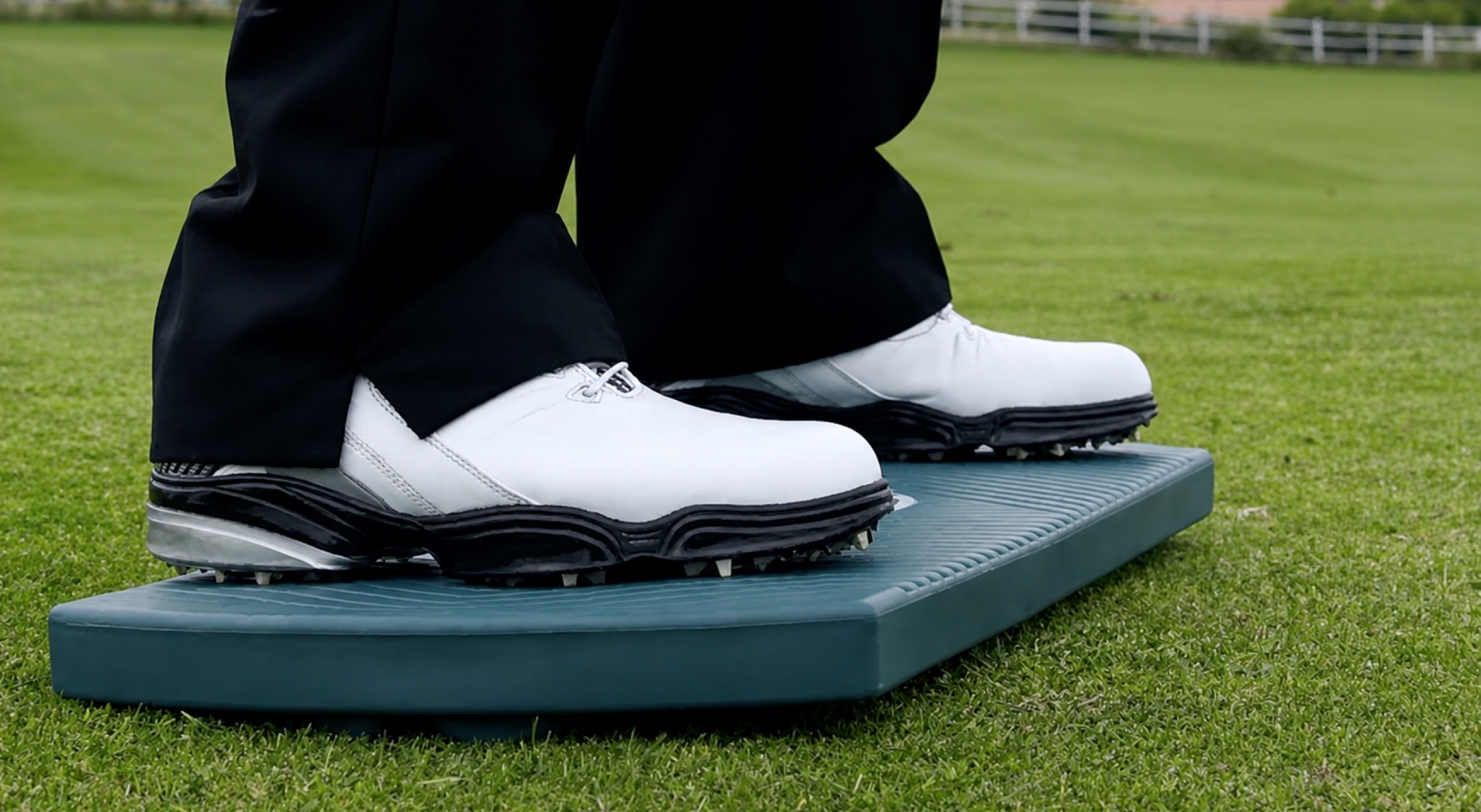 Close-up of golf shoes standing on The Balanced Golfer training board