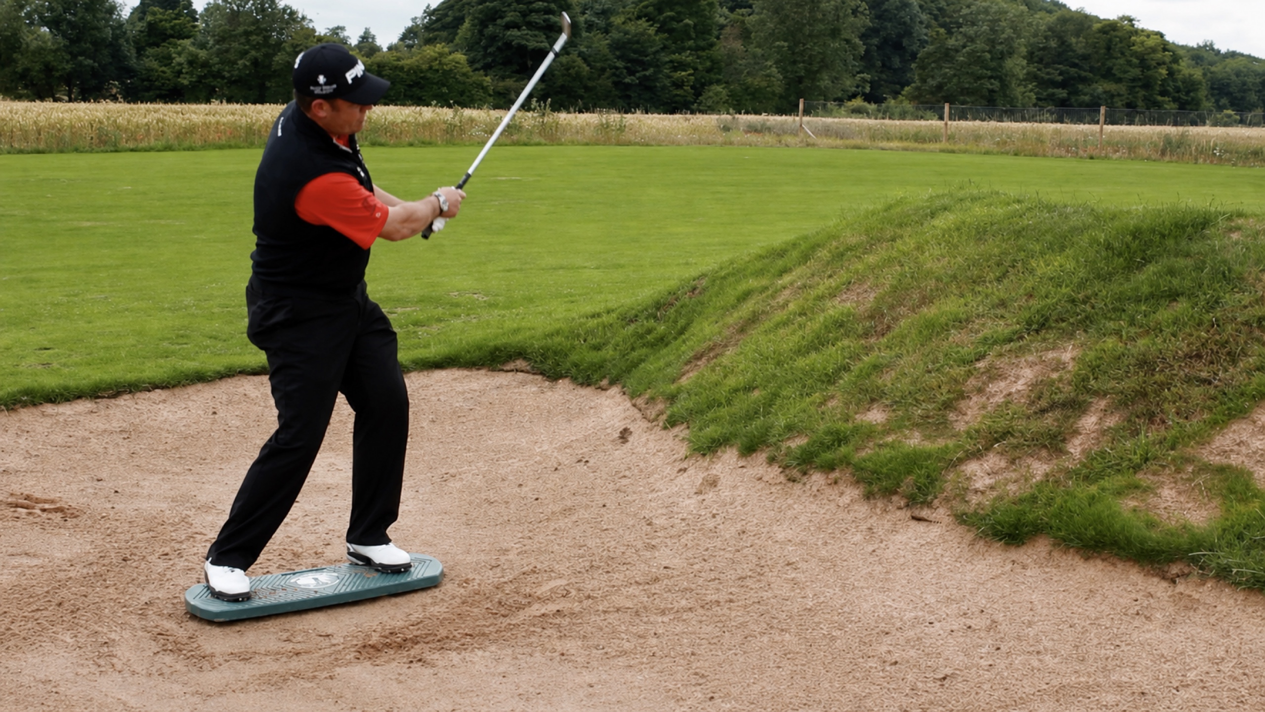 Lee Westwood practising a bunker shot on The Balanced Golfer training board