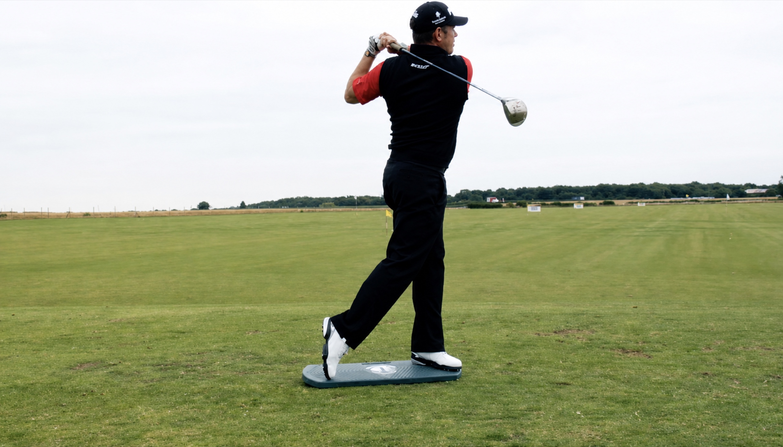 Lee Westwood completing a golf swing on The Balanced Golfer training board