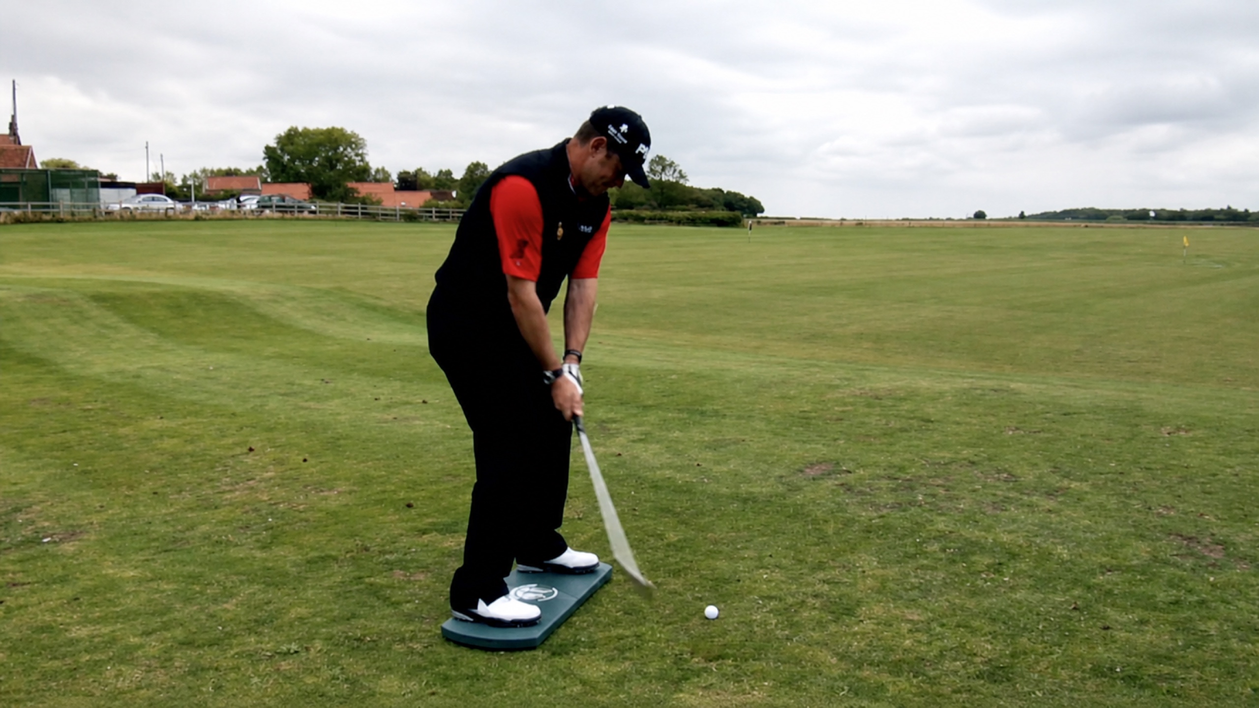Lee Westwood practising a short golf shot on The Balanced Golfer training board
