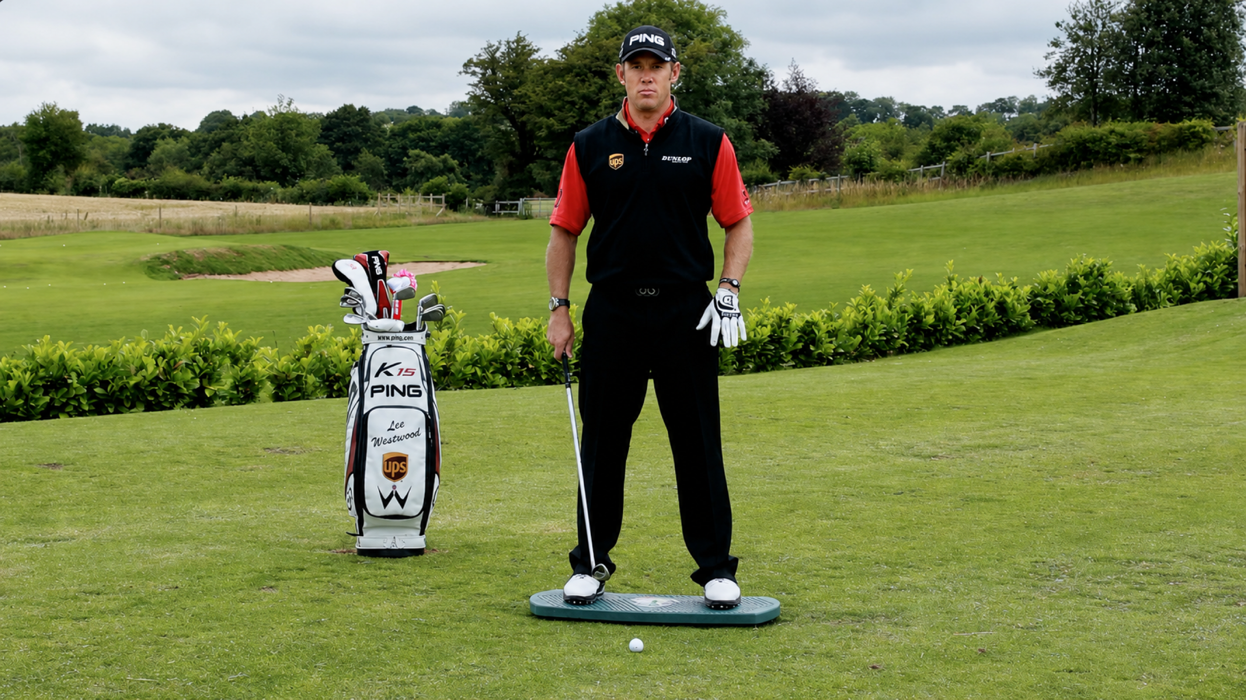 Lee Westwood standing on The Balanced Golfer training board on a golf practice ground